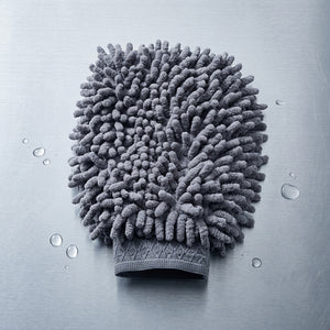 Gray microfiber cleaning glove on a metallic surface with water droplets.