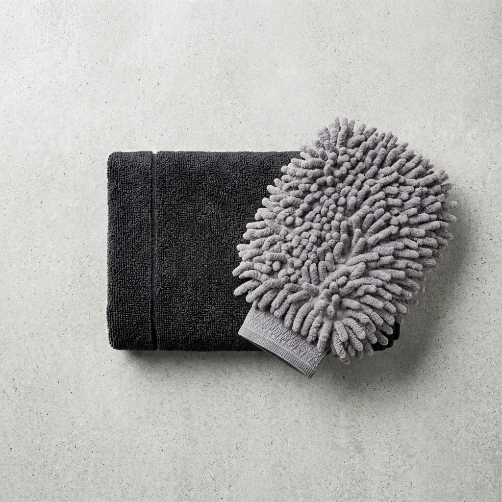 Black towel and gray microfiber mitt/chinnele on a light gray background