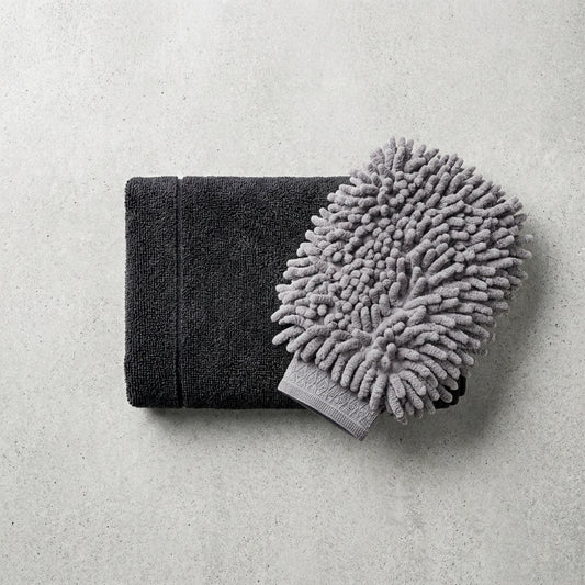 Black towel and gray microfiber mitt/chinnele on a light gray background