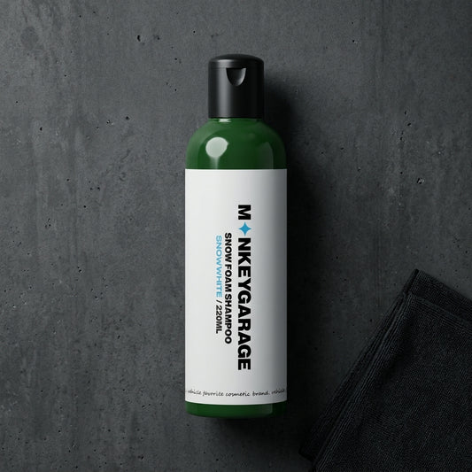 Green bottle of MonkeyGarage snow foam shampoo on a dark gray background